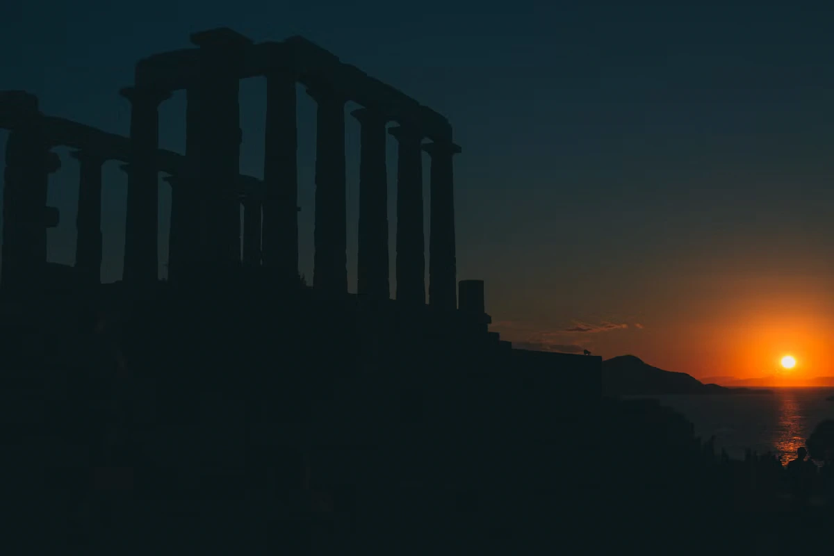 The sun setting behind the columns of the Temple of Poseidon